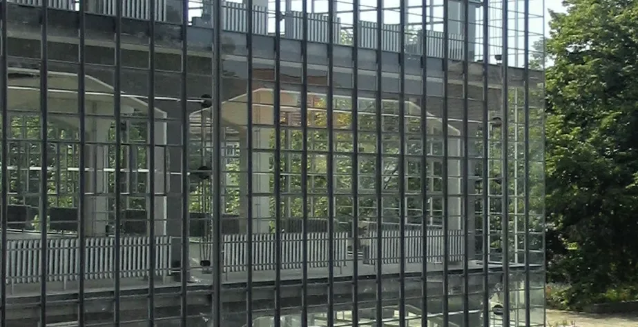 Ściana kurtynowa z szkła w budynku Bauhaus w Dessau, ukazująca wewnętrzną strukturę i nienośną szklaną fasadę.