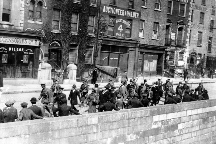Irlandzcy więźniowie maszerujący wzdłuż Bachelors Walk w Dublinie pod brytyjską strażą po Powstaniu Wielkanocnym.
